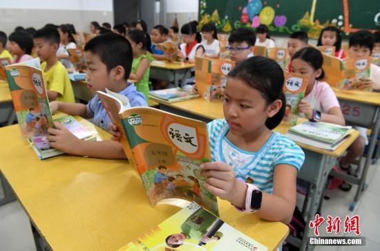 资料图:小学生在阅读统一部编版的语文教材。张斌 摄