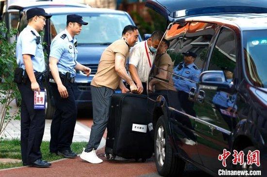 6月7日,在北京市海淀区教育招生和考试中心,工作人员往试卷押运车上搬运试卷。 中新社记者 富田 摄