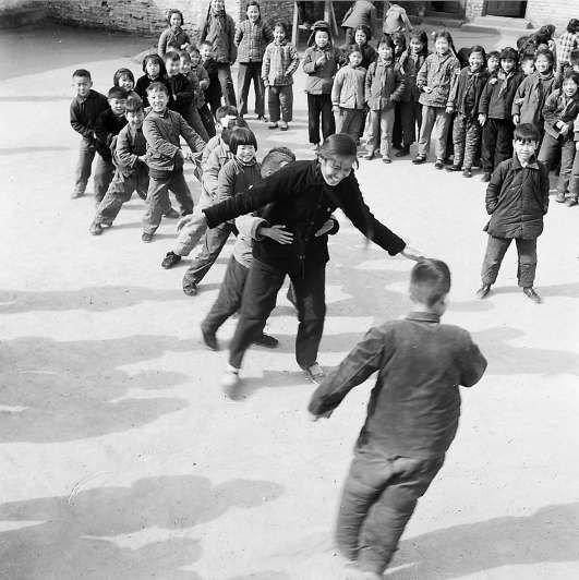 1962年3月,崇文区东八角小学老师和一年级小朋友在课间玩“老鹰捉小鸡”。高宏摄