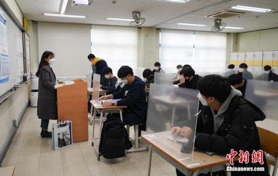 资料图:2020年12月3日,延迟近一个月的韩国高考举行。据韩国教育部消息,今年考生约49.34万人,创历史最低纪录。图为在首尔某考点内,考桌上设有隔板。 中新社发 首尔市教育厅 供图