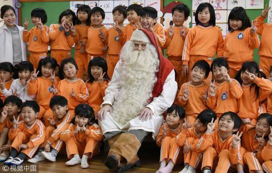 当地时间2018年12月13日,日本冈山,一位来自芬兰的“圣诞老人”探访当地幼儿园并与孩子们合影留念。(视觉中国)