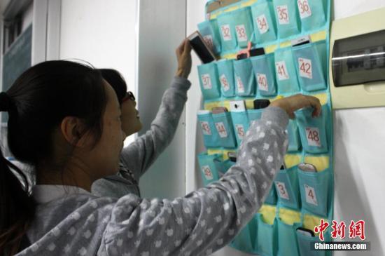资料图:江苏盐城师范学院城市学院学生上课前,将手机关机或者调成静音,放在教室门口统一的袋子里,下课后再自行取走。谷华 摄