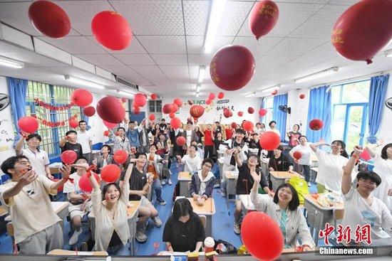 2023年高考前一天,长沙市同升湖高级中学高三年级老师为即将参加高考的考生们派发红包、糕点和粽子,祝福高考生能够金榜题名,一举“糕粽”。杨华峰 摄