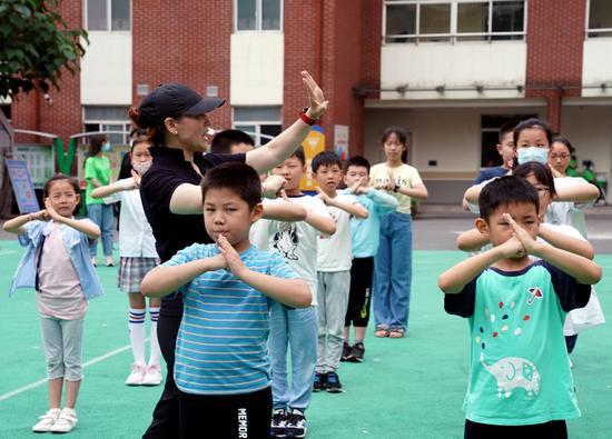 7月5日,在位于上海徐汇区汇师小学分校的爱心暑托班办班点内,小学生在老师指导下练习武术基本动作。新华社记者刘颖 摄