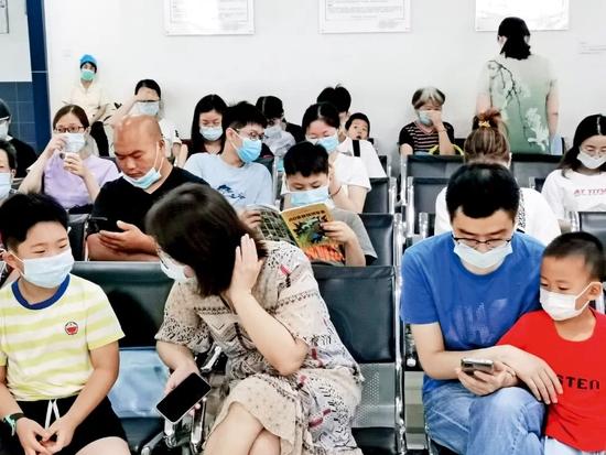 2021年7月21日,江苏苏州市华夏口腔医院里,不少家长带着孩子等待就诊。图/IC