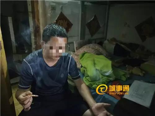 △阿宇酒后点烟,身后的床上睡着他的两个孩子