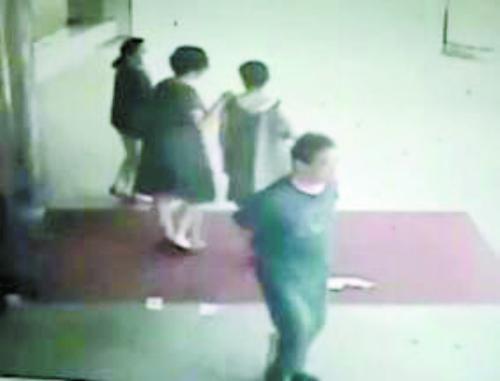 丢钱与捡钱瞬间视频截图 穿裙子的女子与同伴走出门诊大厅