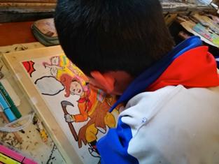 (藏区小学生洛松丁增正在进行作品创作)
