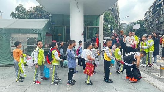 托管服务结束后,孩子们在校门口排队等待家长来接。
