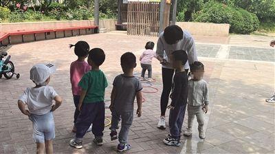 5月10日上午,程琪带家庭托育点的三个孩子到小区“跳房子”,吸引了小区的其他小朋友们一起玩。 新京报记者 李聪 摄