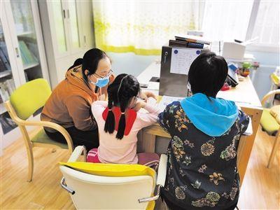 2021年3月8日,陈甜天(左)在学区资源中心为学习障碍学生做个训,学科教师(右)一起跟学。受访者供图