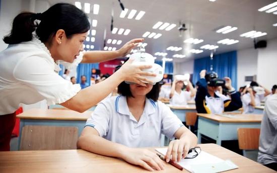 2017年4月,海南海口市的一所中学,学生们通过VR一体机上地理课。图/视觉中国