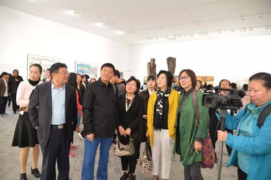 “庆祝中华人民共和国成立70周年特展:心灵之光——济宁市美术馆当代名家邀请展” 展厅现场 策展人裔萼为嘉宾进行导览