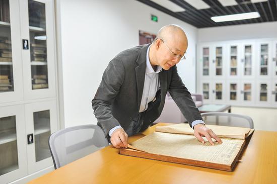 对外经济贸易大学图书馆馆长查阅海关图书馆藏书(《北京周报》记者 魏尧摄)