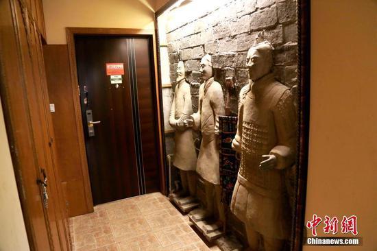 11月27日,民宿进门处的三尊“兵马俑”装饰如同门神。 中新社记者 张远 摄