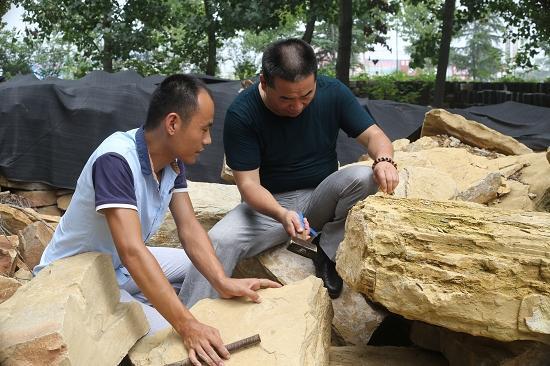 在李春汉的工作室,他与助手在储存的尼山石料中选择制砚的材料。