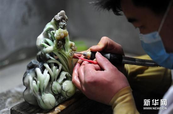 4月7日,在南阳市镇平县“玉雕大师创意园”,工作人员在加工一件玉雕作品。