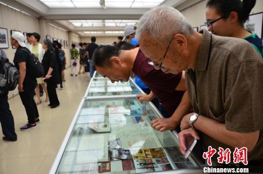 图为:观展民众“品味”30载《黄河母亲》雕塑文献。 崔琳 摄