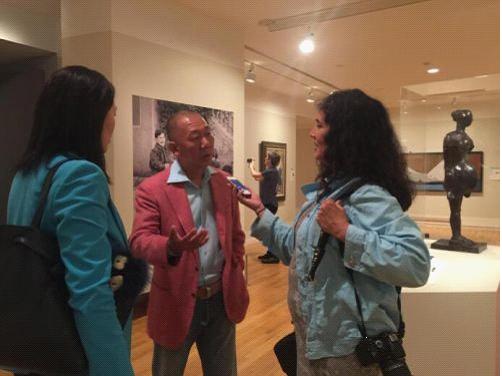 郭庆祥在展览现场接受外媒采访。