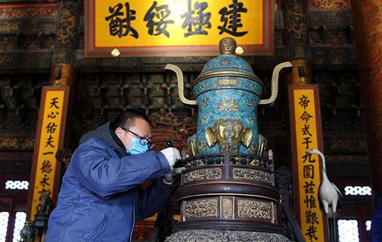 北京故宫太和殿,专家正在清理太和殿内青铜器上的灰尘。