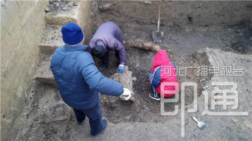 在一个探方里挖掘出一个砖结构建筑,工作人员用小铲和刷子一点一点把周围的土清理掉。