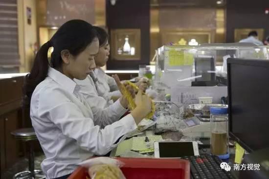 △一家珠宝批发商的销售人员正在整理手中的18K金饰品。