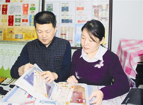 孟永强和妻子一同整理烟标。王海燕摄