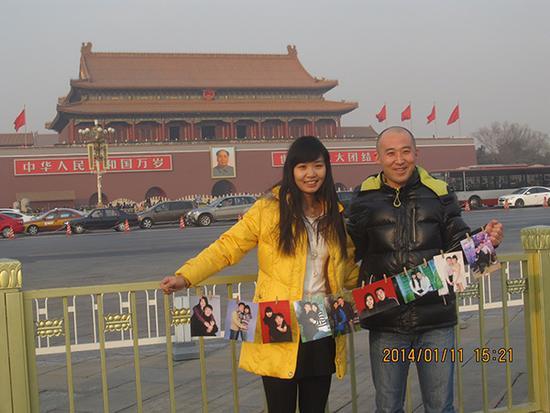 19、一对年轻夫妇带着记录他们恋爱过程的照片来到天安门前,高源看到后,主动给他们拍照留念。