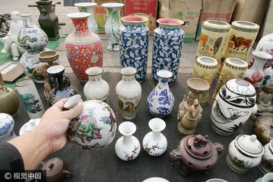 2008年山东潍坊一家古玩地摊市场内,商贩们正在兜售古玩商品。/视觉中国