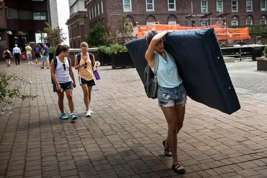 Emma Sulkowicz,哥伦比亚大学视觉艺术学生扛着一个床垫表示学校对于自己在2年级的时候被性侵的事件视而不见的态度的抗议,2014年9月5日。图片:致谢Andrew Burton/Getty Images