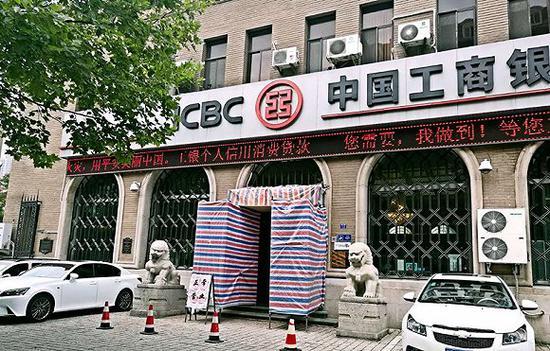 朝鲜银行青岛支行旧址,缺失罗马柱的位置已被编织布围起,但被拆除的罗马柱尚没有被恢复原貌。摄影:牛其昌