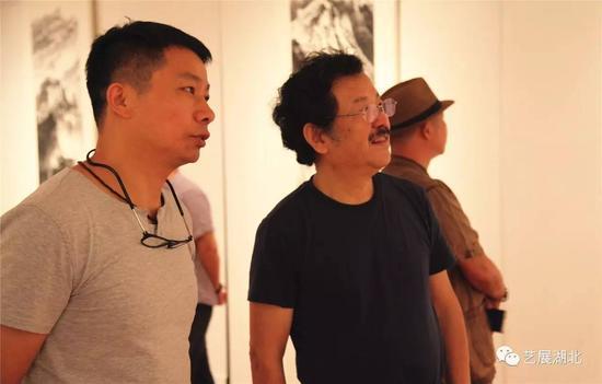 湖北省中国画学会会长施江城(右)等观展