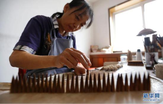 9月19日,李世美在进行毛笔加工的“水盆”工序。 新华网 姜冰摄