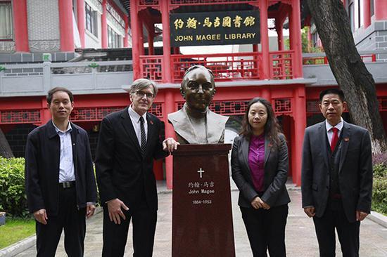 参加仪式的嘉宾与约翰·马吉雕像合影