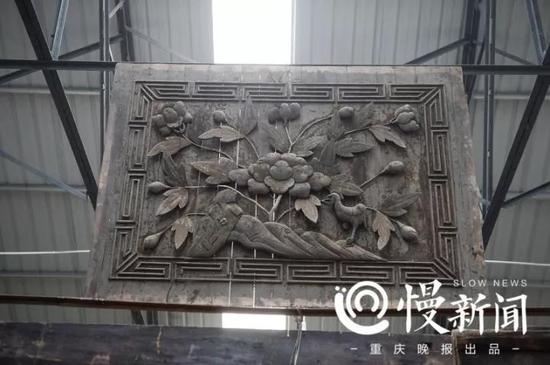 木板雕成花草图案,固定在大厅的墙顶中央。