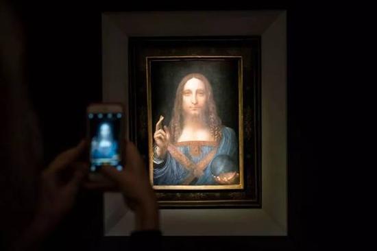 参观者在纽约佳士得给达·芬奇的《救世主》拍照。图片:Drew Angerer/Getty Images