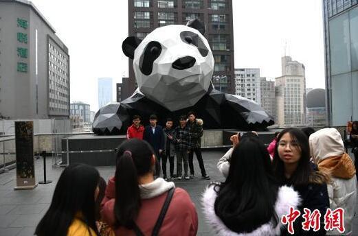 在大熊猫雕塑前合影的市民。 张浪 摄