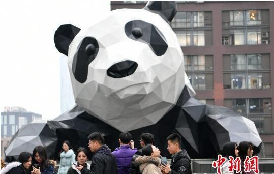 一些情侣来到大熊猫雕塑前合影。 张浪 摄