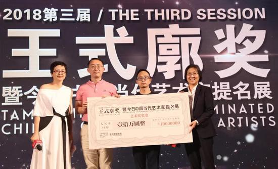 王群女士(右一)与杨大勇先生(左二)为艺术家郑达颁发10万元支票