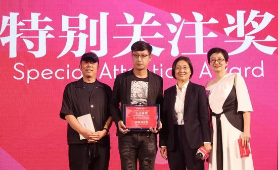 王群女士(右二)、贾国龙先生(左一)为艺术家洛鹏颁奖