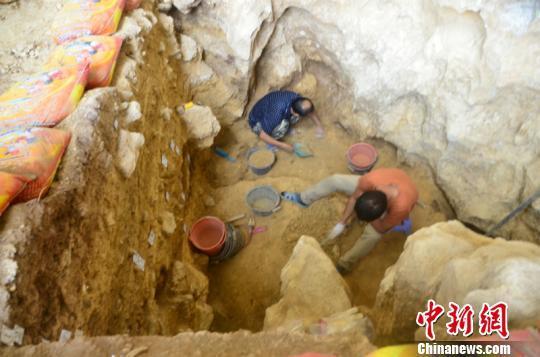 图为工作人员在清理遗址 钟欣 摄