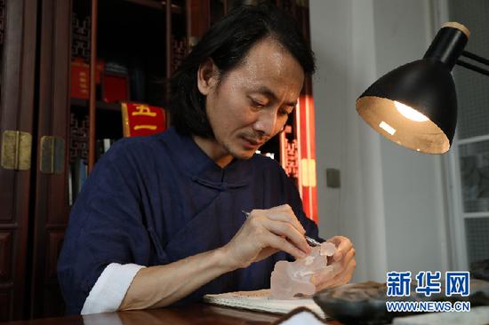 徐利剑在水晶上专心描绘着人物五官。