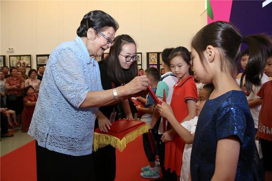 第十届全国人大常委会副委员长、中国关心下一代工作委员会主任顾秀莲为孩子颁发证书