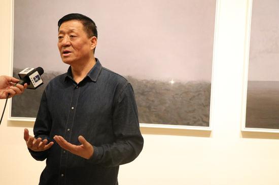 艺术家陈坚展览现场接受媒体采访