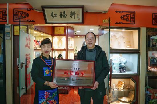 上海市古玩经营协会驻会副会长、宝库汇总经理王承德为红福轩主人翟秀红授牌