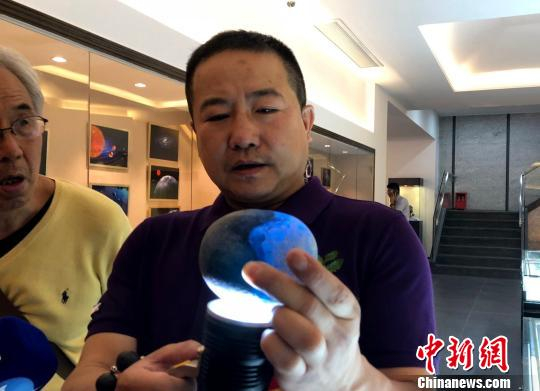 在灯光下发出异彩的玻璃陨石。 陈悦 摄