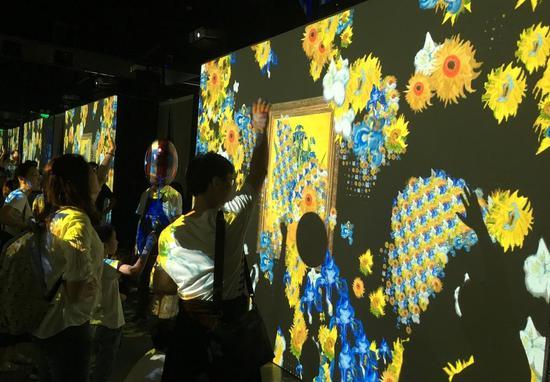 在梵高的花卉作品前,小朋友兴奋不已地挥动手臂与作品互动