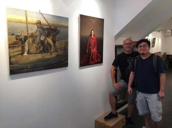 前加拿大安大略省美术学院(ocad)绘画系教授Harvey Chan(左)与香港学生前来参观邸可新画展。