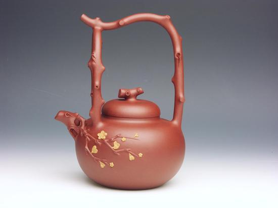 梅花提梁 董正红(董震红)1974年生于陶都宜兴,1997年起在顾绍培工作室进修五年,后又拜中国工艺美术大师吴鸣先生为师,擅长全手工制壶,壶样大气,赋予了紫砂独特的美学意韵