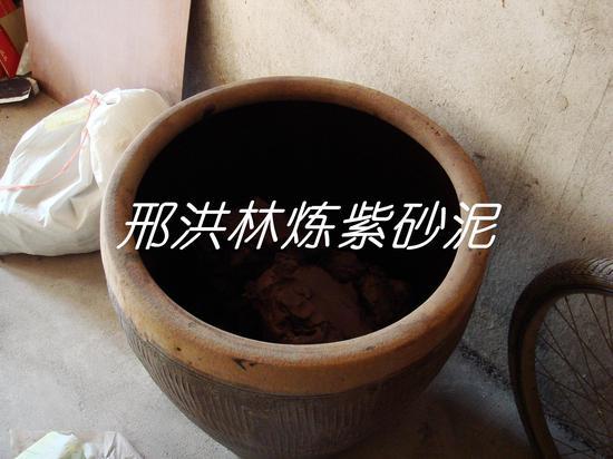 七、把吸收了一些水分的泥用木锤拍打成块,放入缸里,密封一段时间,让其陈腐后,即可用于制壶